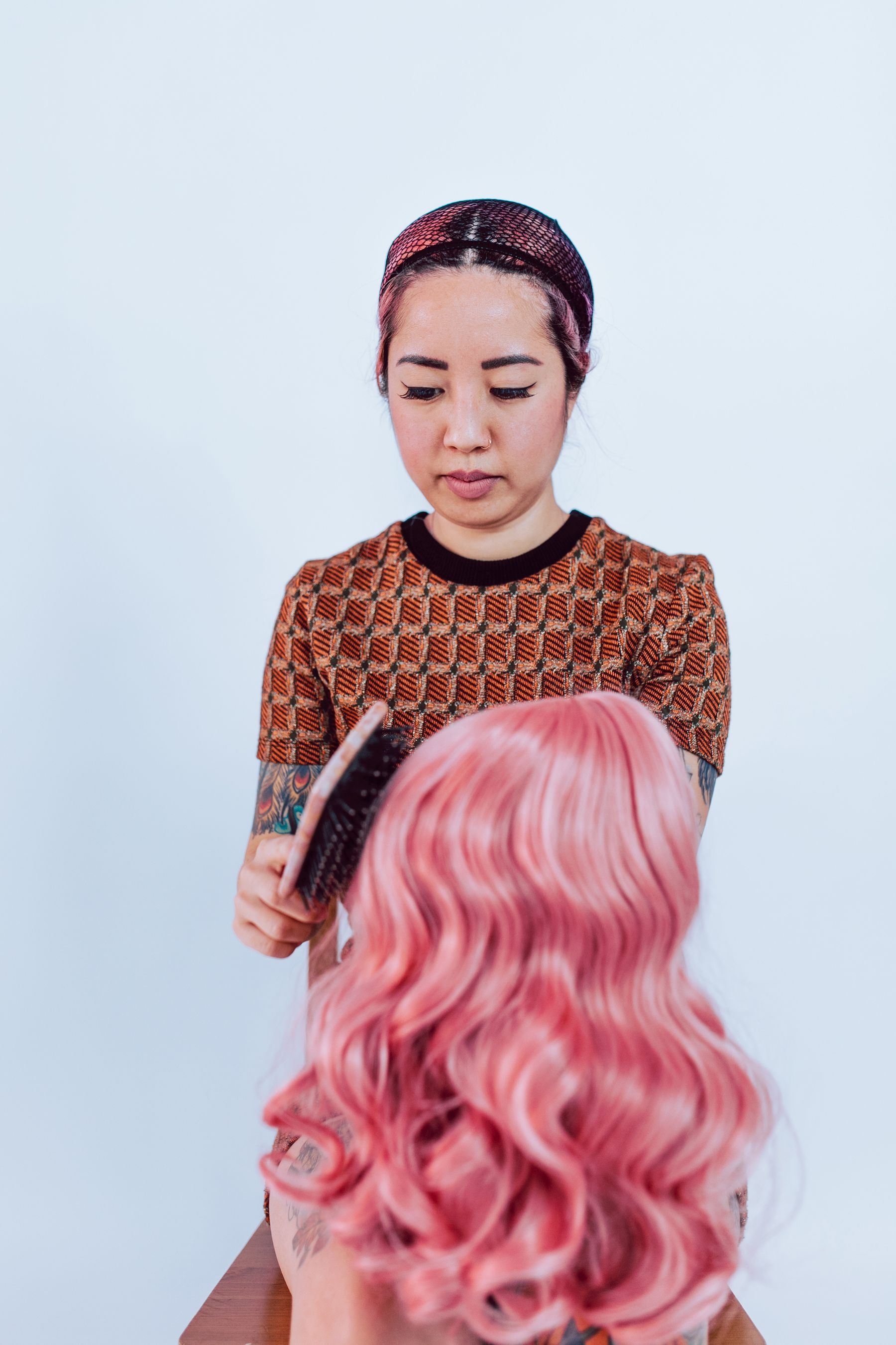 Stylist combing a pink wig
